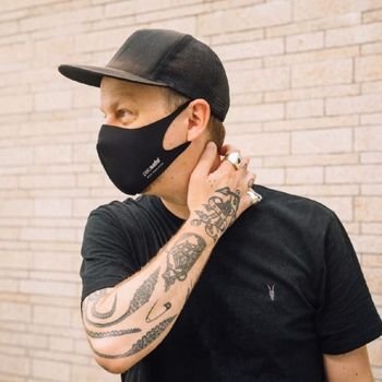 Man with a tattoo wearing a Pacsafe ViralOff Face Mask in black