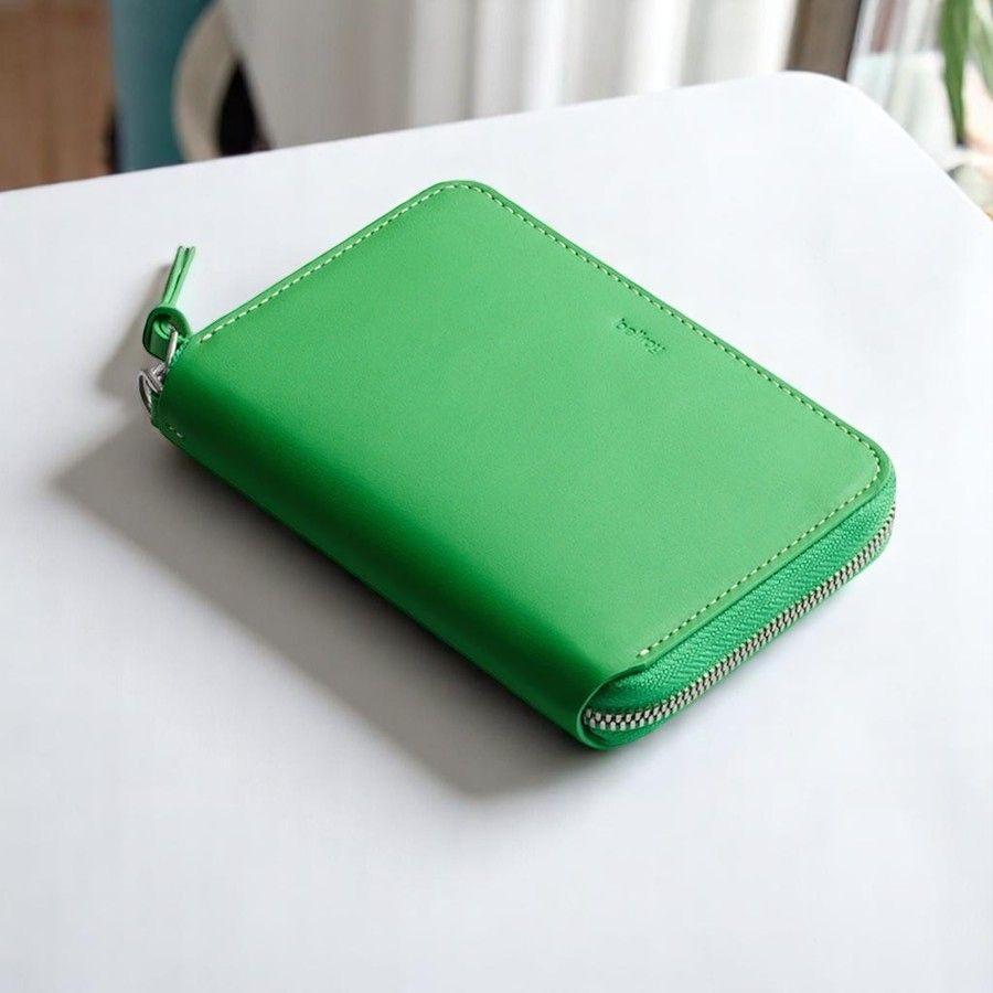 Bellroy Women's Folio Wallet in Neon green on a white table. 