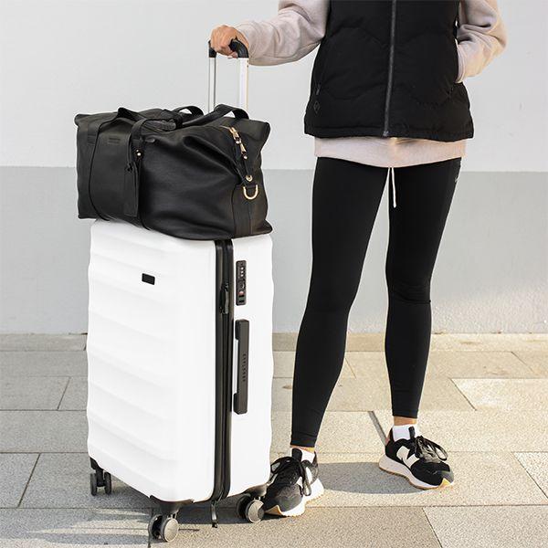 Girl standing with a white luna-air 2 and a black Explorer weekender duffle