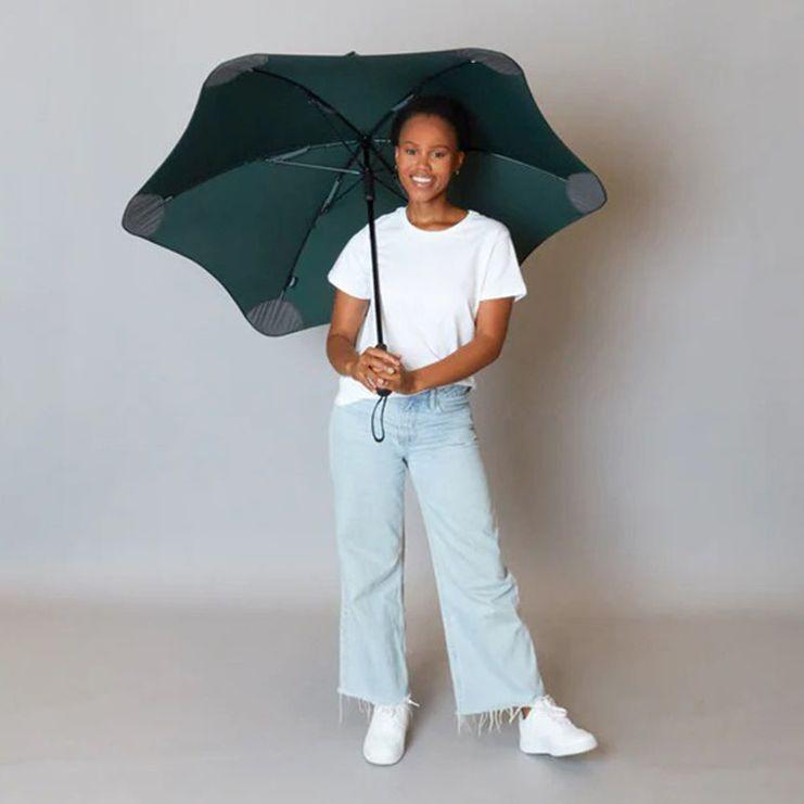 woman holding a dark green umbrella