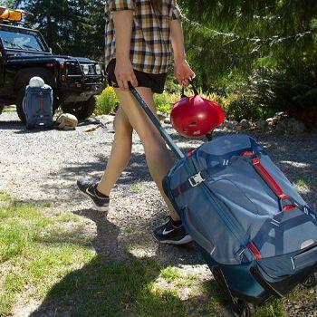 women dragging her eagle creek wheeled duffle along the pebbles