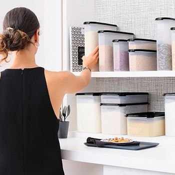 Woman stacking modular mates in her pantry 