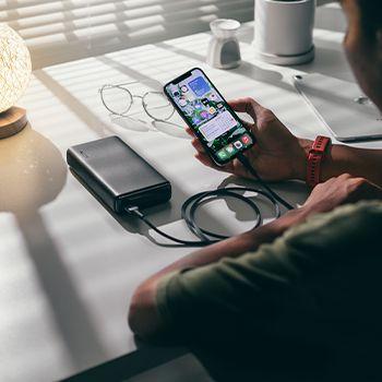 Man using his phone plugged into a power bank