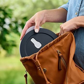 Tupperware Eco+ container being placed into a woman's bag