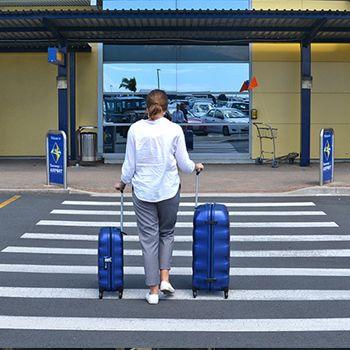 Girl walking across the pedestrian crossing with her small and large Samsonite engenero suitcases