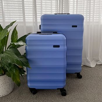 Periwinkle Luna Air 2 suitcases in a bedroom