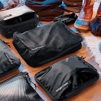 Black Eagle Creek Packing Cubes laid out on the wooden floor