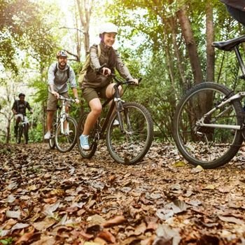 Group of people mountain biking through the forest