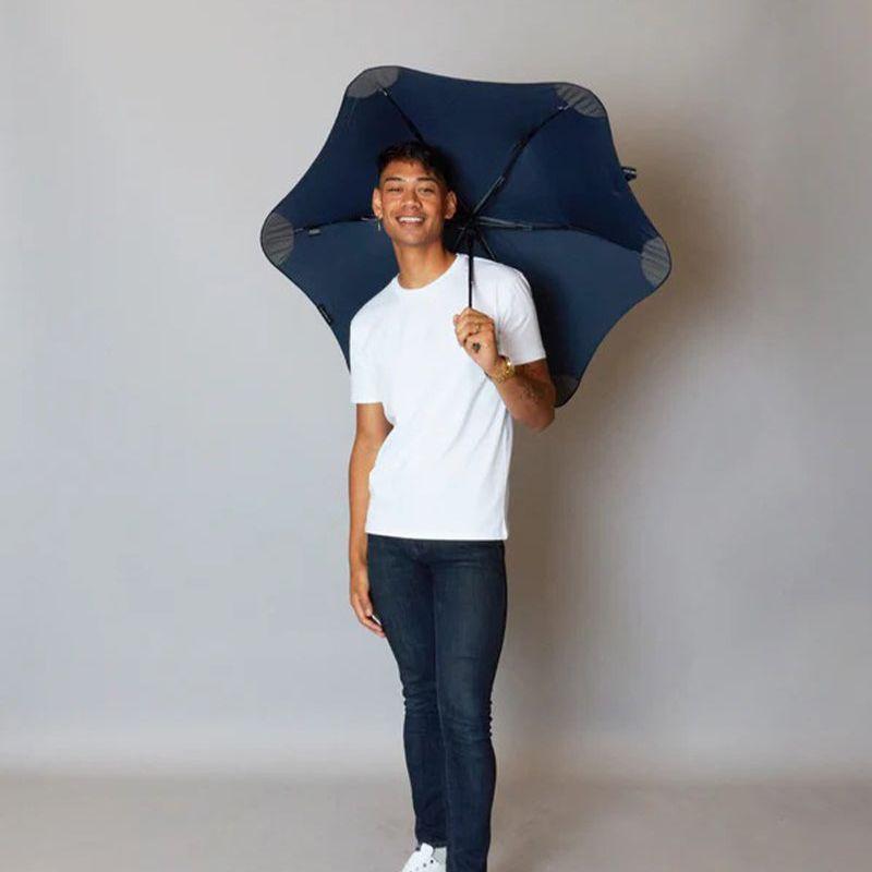 Man holding a dark blue metro umbrella