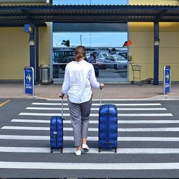 Girl walking across the pedestrian crossing with her small and large Samsonite engenero suitcases